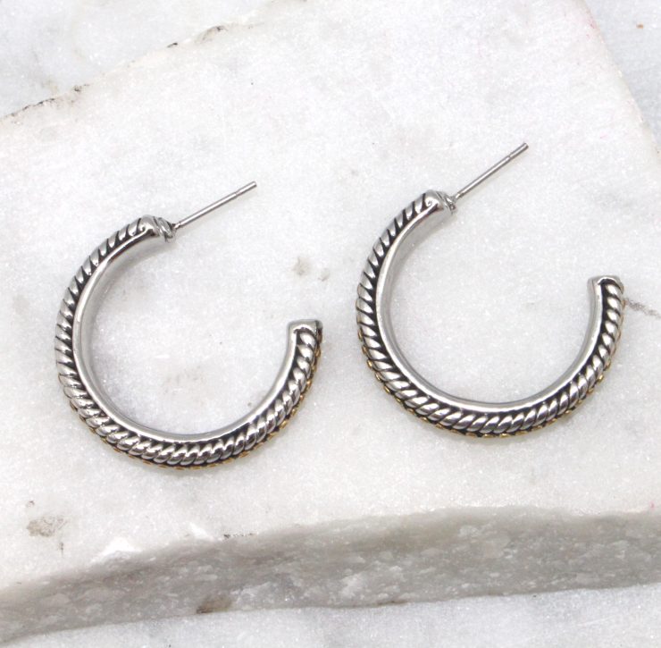 A photo of the Two Tone Braided Hoop Earrings product